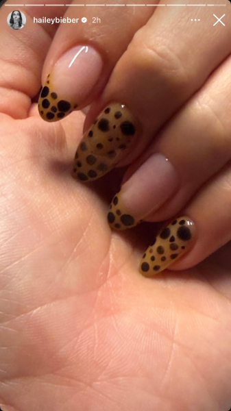 Hailey Bieber shows off her cheetah print nails a mix of French tips and fully painted nails.